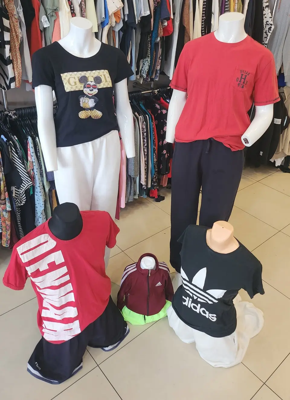 Ladenauslage: bedruckte T-Shirts, Jogginghosen und Sportschuhe für Erwachsene und Kinder